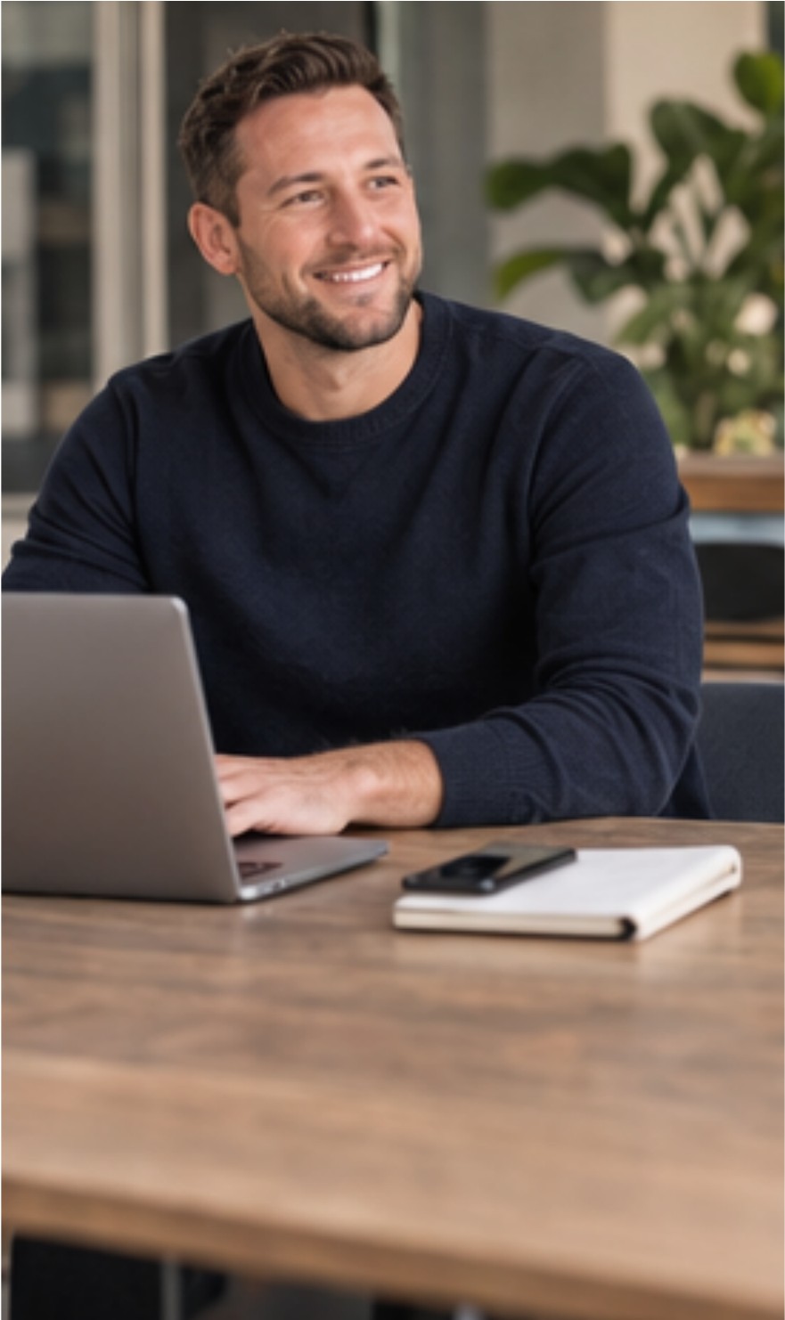 Gastón sonriendo frente a la laptop en una mesa de trabajo